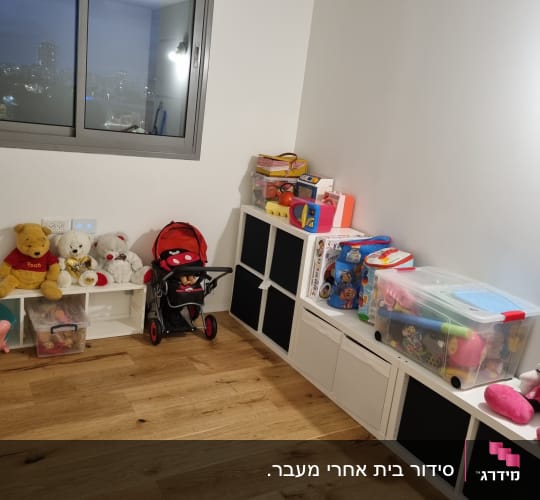 צעצועים מאורגנים על מדפים וקופסאות פלסטיק בחדר ילדים